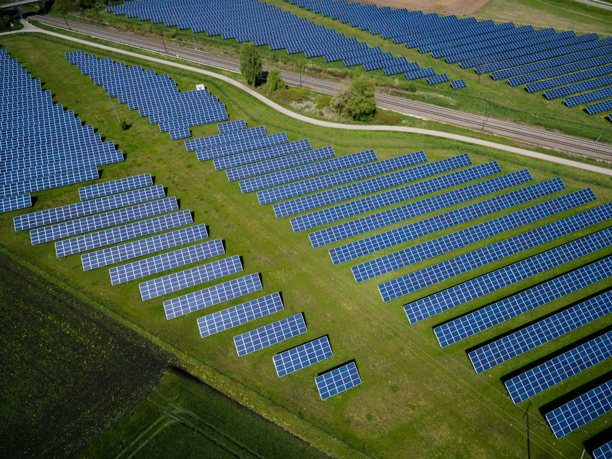 Aerial view of rows of solar panels in a field