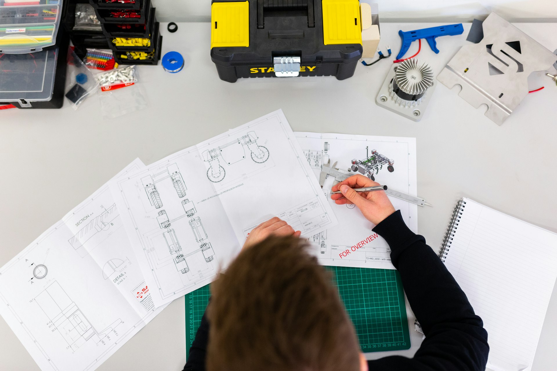 Engineer reviewing technical drawings at a workbench