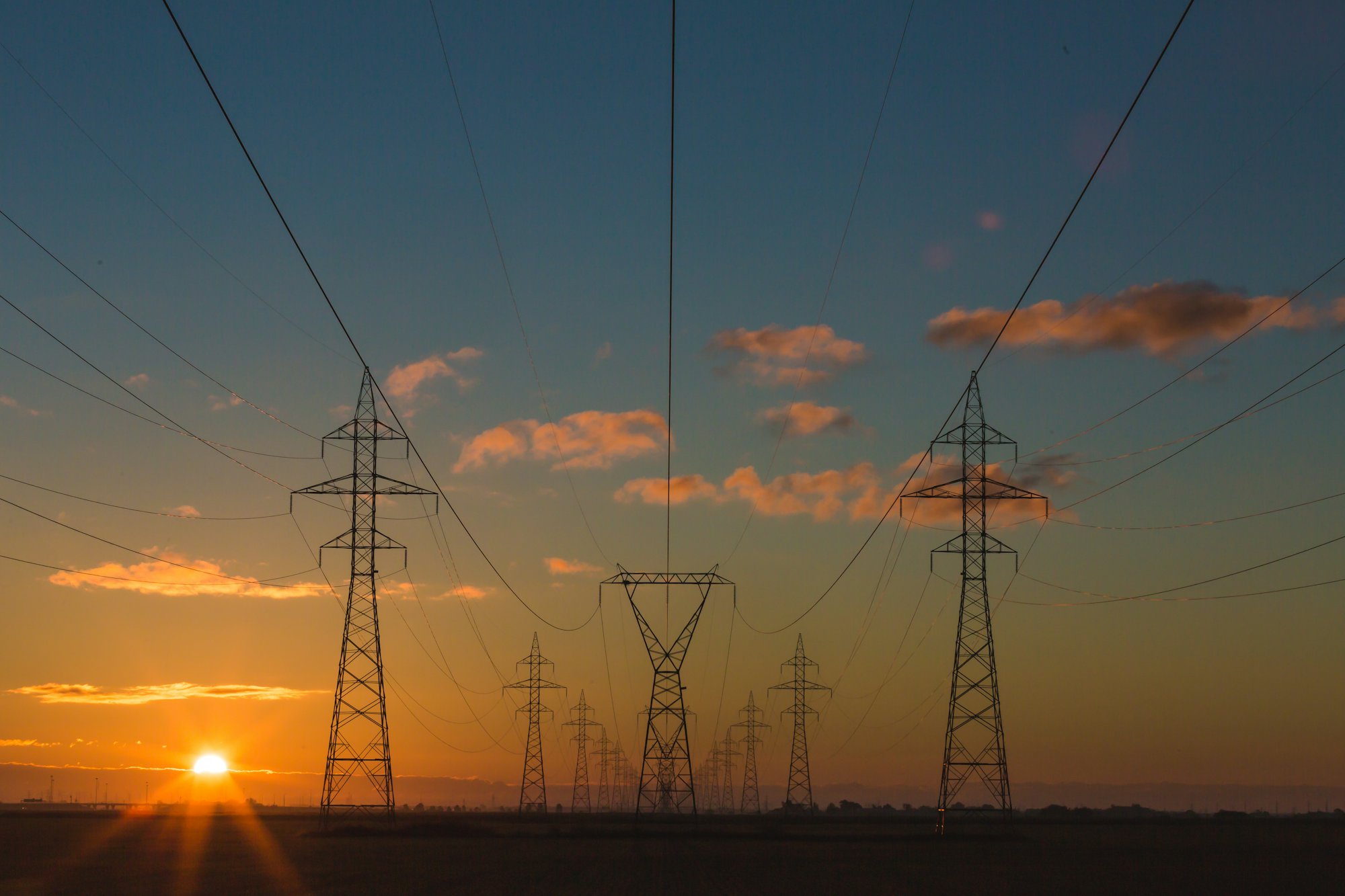 High-voltage transmission towers at sunset